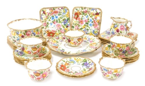 An early 20thC Hammersley porcelain part tea service, painted all over with flowers, gilt heightened, pattern no. 131666, printed and painted marks, comprising, bread plate, cream jug and sugar bowl, five tea cups, twelve saucers and tea plates.