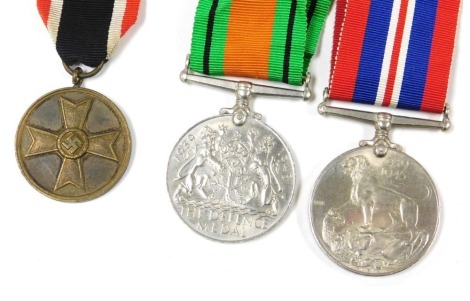 A WWII Third Reich War Merit Medal, with a War Merit Cross ribbon, together with a British Defence Medal, and a 1939-45 War Medal. (3)