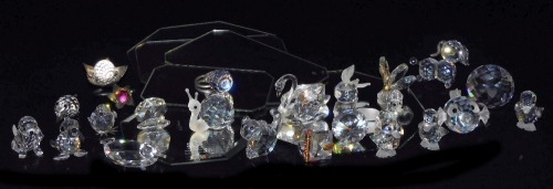 A group of Swarovski and other crystal figures, including dogs, baby seal, puffer fish, fox, cat and ducklings, together with two Swarovski crystal boxes and six mirrored display stands. (a quantity)