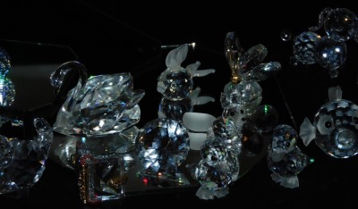 A group of Swarovski and other crystal figures, including dogs, baby seal, puffer fish, fox, cat and ducklings, together with two Swarovski crystal boxes and six mirrored display stands. (a quantity) - 3