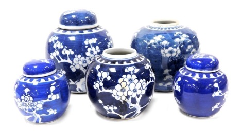 A 19thC Chinese blue and white ginger jar, decorated with prunus blossom against a scale ground, and four 20thC blue and white ginger jars, three with covers, similarly decorated. (5)