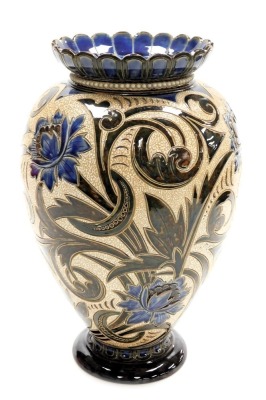 A late 19thC Doulton Lambeth stoneware vase, dated 1886, by Emily London and Elizabeth Adams, sgraffito decorated with blue flowers and scrolling leaves on a textured ground, impressed and incised marks, 36cm high.