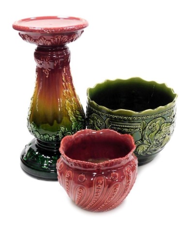 A late 19thC pottery jardiniere stand, of baluster form, moulded with leaves, decorated in a graduated red to green glaze, 43cm high, together with a green glazed pottery jardiniere decorated in the Gregorian pattern, 21cm high, and a smaller red glazed j