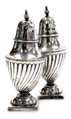 A pair of Edward VII silver pepperettes, of neo-classical semi spiral fluted form, Sheffield 1905, 2.2oz.