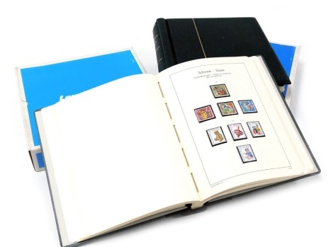 Two Leuchtturm stamp albums, containing Swiss stamps in chronological order, with outer cardboard packaging.