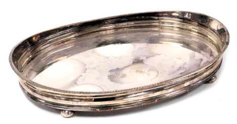 A 19thC silver plated oval galleried tray, with a gadrooned rim, raised on bun feet, 47cm wide.