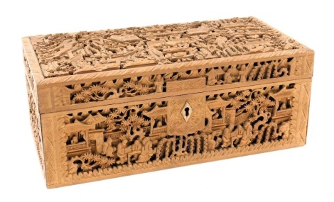 A late 19thC Chinese wooden box, of rectangular section, profusely carved with figures in a garden, with pagodas and trees beyond, 25.5cm wide, 13cm deep.