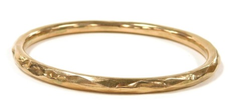 A 9ct rose gold bangle, of faceted form, 8.0g, 8.5cm wide.