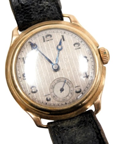 A mid-Century lady's 9ct gold cased wristwatch, circular silvered dial with engine turned decoration, Swiss jewelled movement, the case of circular plain form, on a leather strap.