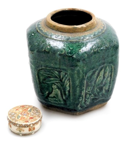 An early 20thC Chinese green Shiwan pottery ginger jar, of hexagonal form, decorated with panels of figures, birds, and script, 13cm high, together with a Japanese Satsuma cylindrical rouge pot and cover, 4.5cm wide. (2)