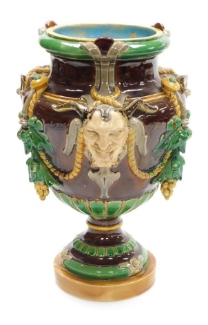 A late 19thC majolica vase, probably Minton, of baluster form, moulded with Bacchanalian masks, vines and rope swags, 32.5cm high. (AF)