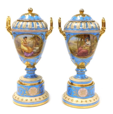 A pair of 19thC Vienna style porcelain vases and covers, of twin handled ovoid form, raised on a plinth base, painted with reserves of classical figures, on a pale blue ground, gilt heightened, 24cm high. (AF)