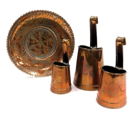 Three early 20thC copper dairy measures, engraved for Trent Dairies, together with a copper dish with engraved floral and foliate decoration, 25cm wide.