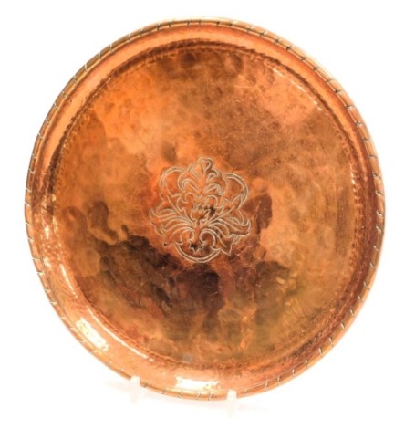 Hugh Wallace (1871-1944). A circular copper salver, with central engraved foliate decoration, square frame monogram, 28cm wide.