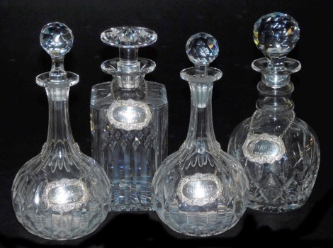 A pair of Victorian cut glass globe and shaft decanters, two further cut glass decanters, and four silver decanter labels, for Sherry, Whisky, Port and Brandy, Birmingham 1977, 1.91oz.