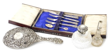 A group of small silver, to include an Edward VII cut glass silver topped scent bottle, of globular form, the lid repousse decorated with scrolls and flowers, lacking stopper, Birmingham 1902, 11cm high, a silver backed hand mirror (AF), silver and enamel