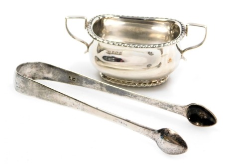 A pair of Georgian silver sugar tongs, and a Victorian silver twin handled salt, with a gadrooned rim, Atkin Brothers, Sheffield 1900, 3.16oz. (2)