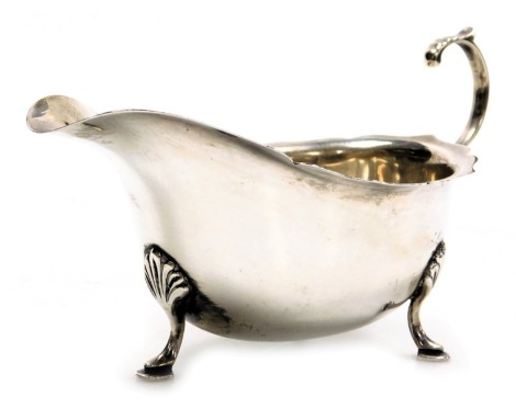 A George VI silver sauce boat, with a scroll handle, raised on three hoof feet, Birmingham 1937, 3.72oz.