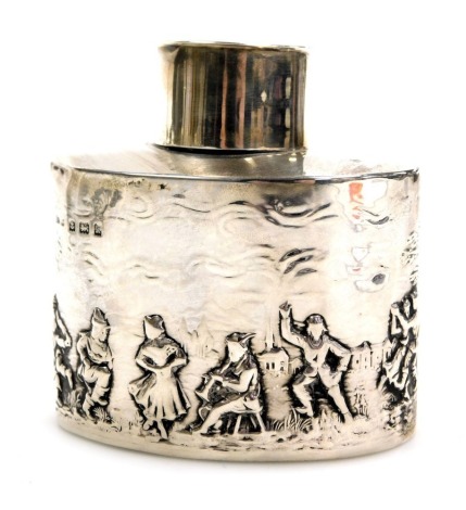 An Edward VII silver tea caddy, of oval, lidded form, repousse decorated with a country pastoral scene of figures dancing, Birmingham 1909, 2.48oz.