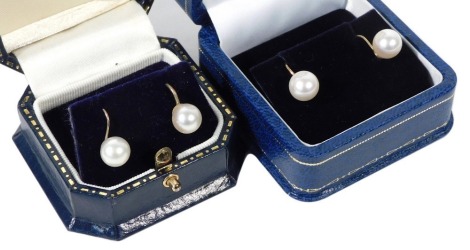 Two pairs of 9ct gold and cultured pearl single earrings, on hoop and screw attachments, boxed.