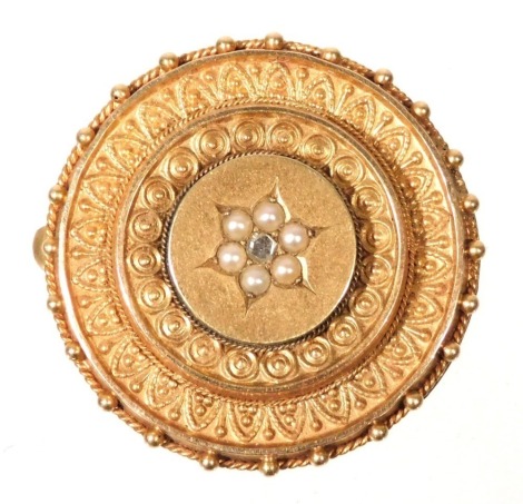 A Victorian Etruscan style locket brooch, of circular, tiered form, set centrally with a flower head of seed pearls and an old cut diamond, in yellow metal, 5.5g. (AF)