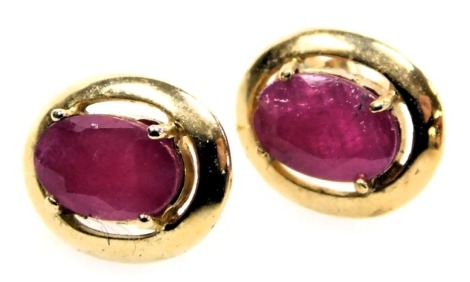 A pair of 9ct gold and ruby single stone earrings, in an oval, claw setting,