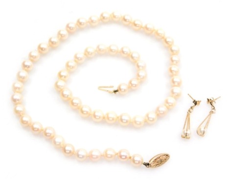 A string of cultured pearls, of uniform size, on a clasp stamped 14k, together with a pair of 9ct gold and cultured pearl drop earrings.