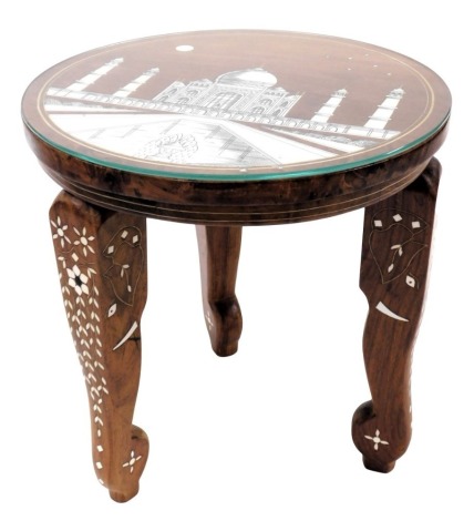 An Indian sheesham wood and bone inlaid occasional table, the circular top decorated with Taj Mahal, raised on three elephant's head legs, 30cm high, 30cm wide.