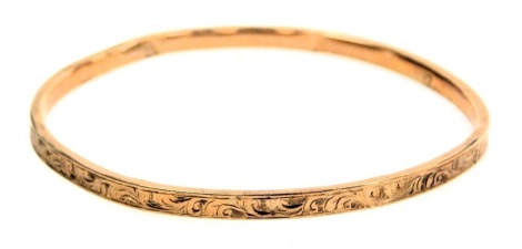 A rose metal bangle, with engraved foliate decoration, stamped 9ct, 4.5g.