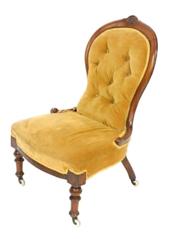 A Victorian mahogany spoon back nursing chair, with overstuffed button back gold fabric and overstuffed seat, raised on turned legs, on castors, 61cm wide, together with a pair of Edwardian mahogany carver chairs. (3)