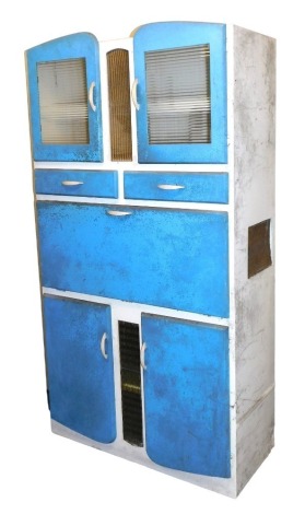 A vintage mid century larder cupboard, in turquoise blue and white, with a pair of perspex fronted doors, over two drawers, above a drop down section, with three recesses and an egg tray, over two further cupboard doors, 189cm high, 101cm wide, 46cm deep