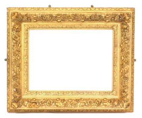 A Victorian gilt wood and gesso picture frame, decorated with flowers and scrolling leaves, 83cm x 98cm.