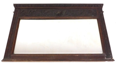 A Victorian carved oak over mantel mirror, the pediment with leaf carving, over a frieze with a lion's head and scrolling leaves, above a rectangular plate, 84cm x 129cm.