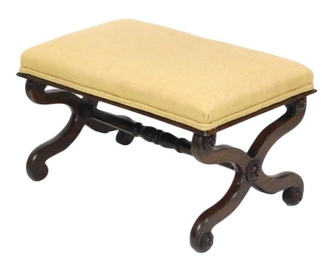 A Victorian rosewood stool upholstered in overstuffed yellow fabric, raised on X framed supports united by a turned stretcher, 64cm wide.