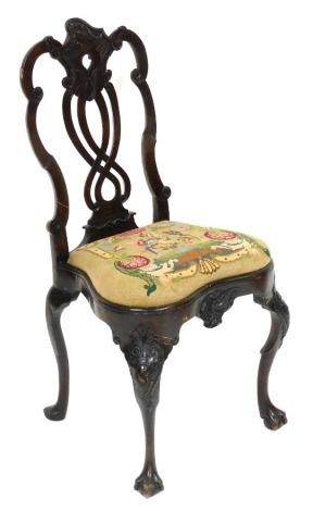 An 18thC Dutch walnut dining chair, with foliate carved and pierced splat, woolwork tapestry seat, raised on rococo foliate carved cabriole legs on ball and claw feet, 50cm wide.