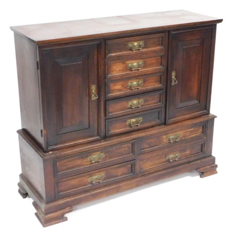 A Victorian mahogany chest, with five central drawers, flanked by a pair of cupboard doors, over four further drawers, raised on ogee bracket feet, 94cm high, 108cm wide, 38cm deep.