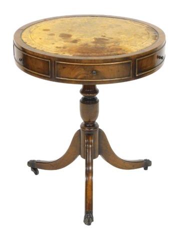 A Georgian reproduction mahogany drum occasional table, with a gilt tooled yellow leather top, three side drawers and three dummy drawers, raised on a turned column, over three cabriole legs, brass capped on castors, 59wide, 50cm diameter.