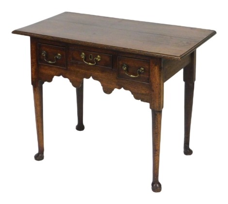 An 18thC Georgian oak lowboy, with one short and two deep drawers, raised on turned legs, on pad feet, 71cm high, 91cm wide, 49cm deep.