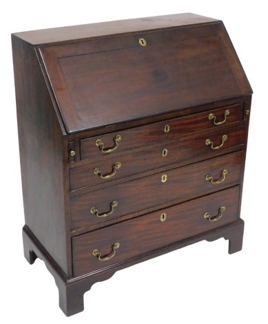 A George III mahogany bureau, the fall opening to reveal a fitted interior with central door above a short drawer, flanked by semi secret compartments, fronted by demi balusters, and eight further drawers and recesses above four long graduated drawers, ra