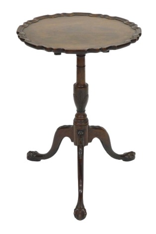 A George III mahogany occasional table, with a pie crust top, raised on a turned column carved with corn, above three cabriole legs, carved with harebells to the knee, on ball and claw feet, 71.5cm high, 50cm diameter.