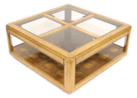 A late 20thC Waring and Gillow oak coffee table, of square section, inset with four bevelled glass panels, above a parquetry under tier, on a block base, 41cm high, 97cm wide, 97cm deep.