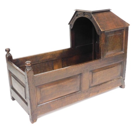 An 18thC oak crib, with a panelled canopy and sides, raised on stiles, 82cm high, 111cm wide, 49cm deep. (AF)