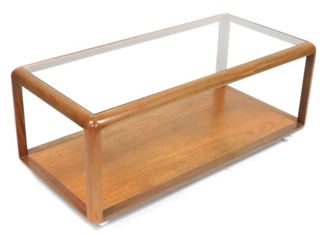 A G Plan teak and glass topped coffee table, of rectangular section, raised on straight supports united by an under tier, on castors 45cm high, 111cm wide, 53cm deep.