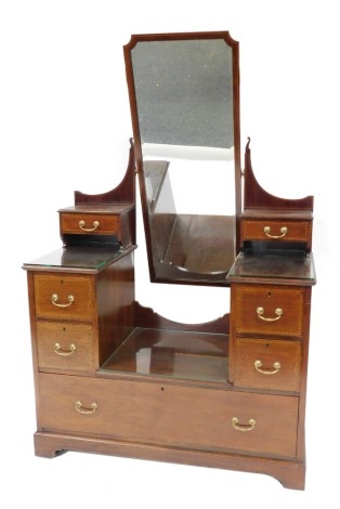 An Edwardian mahogany dressing chest, with barber's pole crossbanding, the central swing frame cheval mirror, flanked by a super structure with two short drawers, over four deep and one long drawer, raised on bracket feet, 179cm high, 114cm wide, 54cm dep