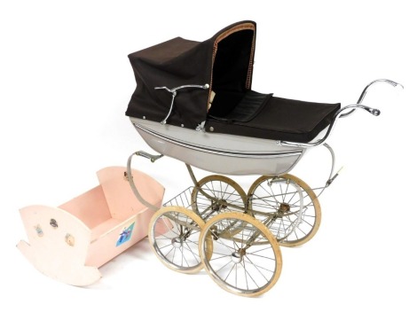 A Silver Cross pram, with a grey chassis and brown fabric hood and child protector, 94cm long, together with a pink painted wooden vintage cradle, 46cm wide, 44cm deep.