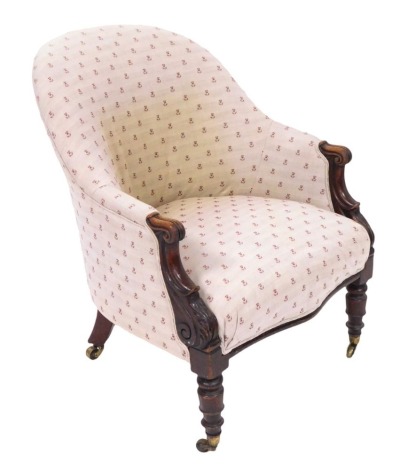 A Victorian armchair, the curved back on oak carved legs with scroll design detailing with a pale pink and red dandelion detailed material, 82cm high, 64cm wide, 70cm deep.