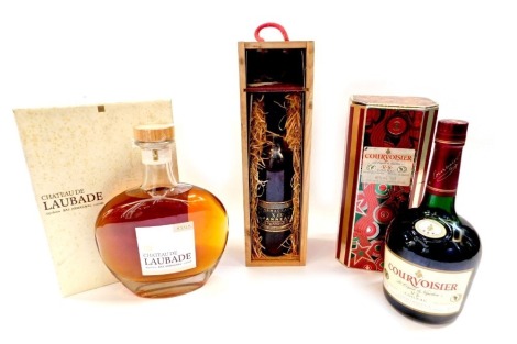 A bottle of Chateau De Laubade V.S.O.P. Armagnac, a small bottle of Janneau X.O. Armagnac, and a bottle of Courvoisier V.S. Cognac. (3)