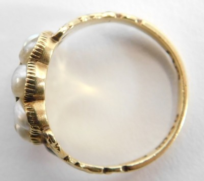 A George IV gold and pearl cluster memorial ring, with a central brass locket and surround of eight pearls, black enamelled shoulders, hallmarked for London 1827 and inscribed ? Atkinson 16th May 1827 ...., ring size L 1/2, with ring box. - 2