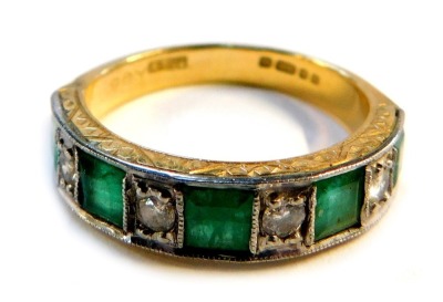 An Elizabeth II emerald and diamond dress ring, channel set, with miligrain borders and floral engraved sides, London 1976, size P 1/2, 5.8g all in.