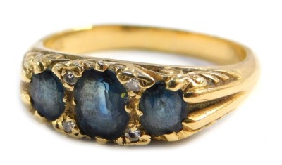 A sapphire and diamond dress ring, set with three marquise cut sapphires, with tiny diamond breaks, on a yellow metal shank, stamped 18ct, size P 1/2, 6.3g all in.